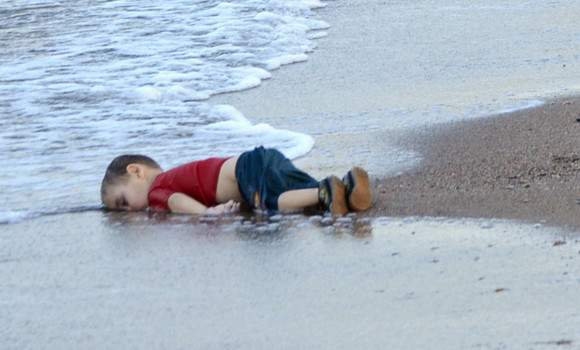 epa04910104 Washed up body of a refugee child who drowned during a failed attempt to sail to the Greek island of Kos, at the shore in the coastal town of Bodrum, Mugla city, Turkey, 02 September 2015. At least 11 Syrian migrants died in boat sank after leaving Turkey for the Greek island of Kos.  EPA/DOGAN NEWS AGENCY ATTENTION EDITORSgraphic content 
ATTENTION EDITORS: PICTURE CONTAINS GRAPHIC CONTENT ; TURKEY OUT